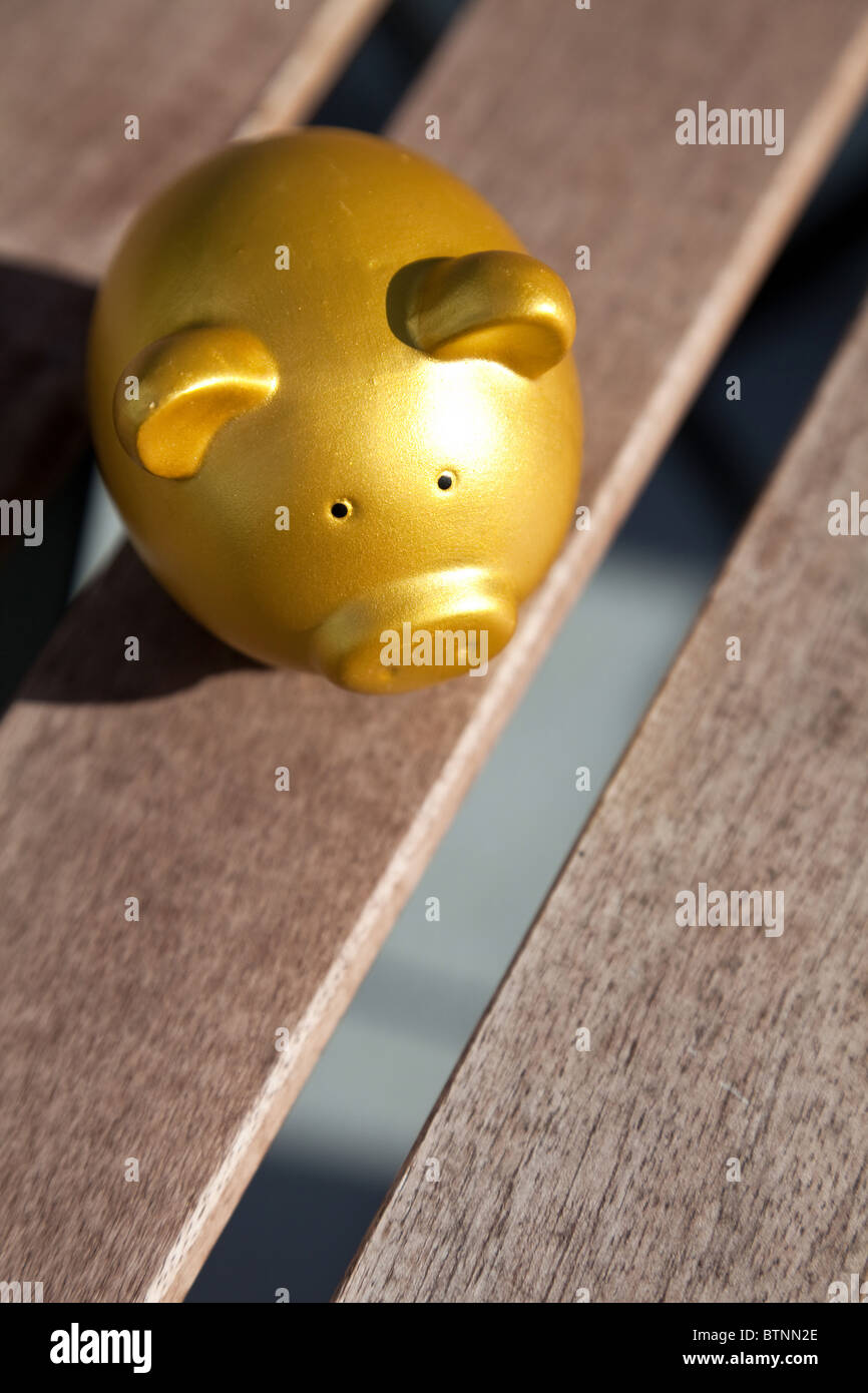 Gold Piggy Bank on wood table top Stock Photo - Alamy