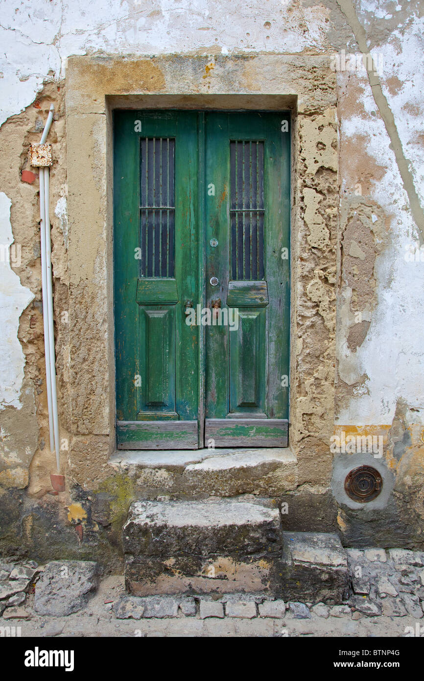 Green Wood Door with Hand Carved Stone in the Medieval Village Of Obidos Stock Photo