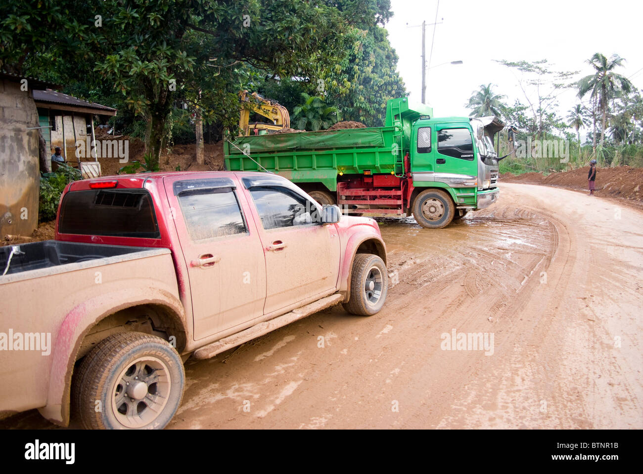 vehicles at work clearing muddy road after the passage of hurricane