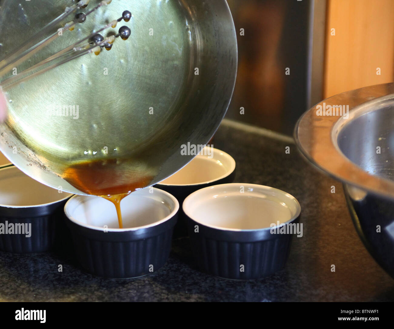 Pan pouring caramel in pots for making creme caramel Stock Photo Alamy