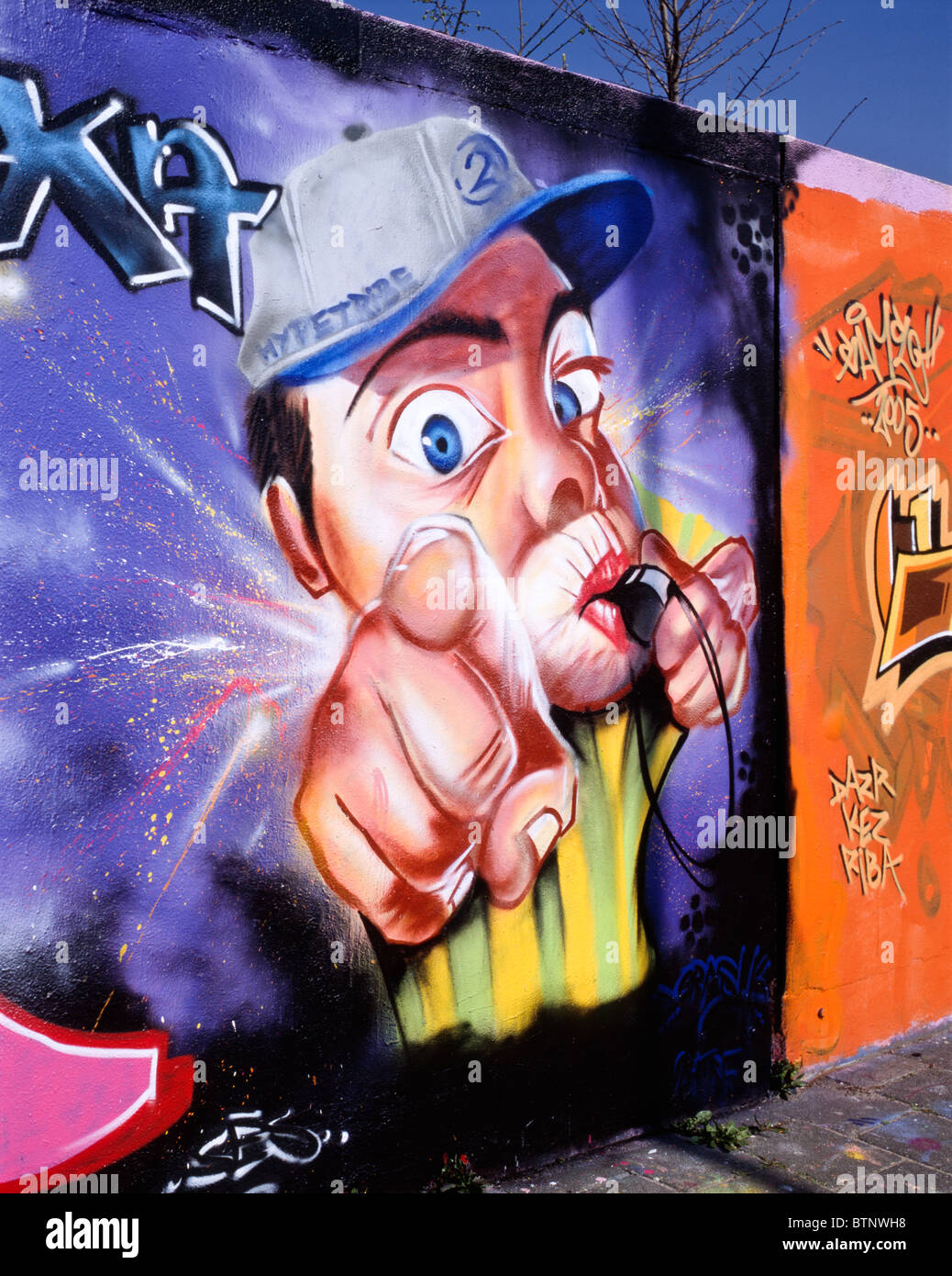 Graffiti of a man with a base cap pointing his index finger at the observer  / viewer while blowing into a whistle, Delft Stock Photo - Alamy
