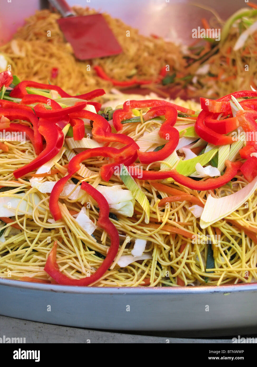 Fried noodles with vegetables in a frying pan on a food stand at the Fall Fair (Herbstmarkt) in Rheinfelden, Switzerland. Stock Photo