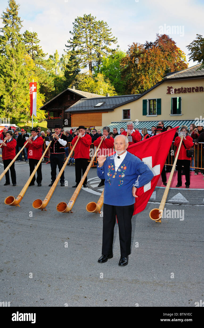 Swiss flag man. An older Swiss flag-thrower at the end of his performance as alphorns are played in the background. Stock Photo