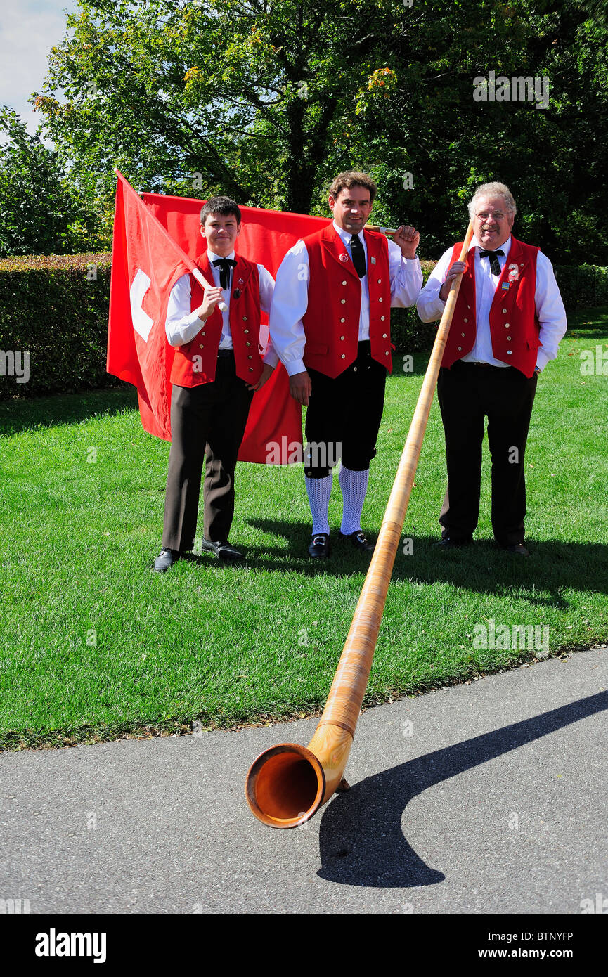 Two Swiss flag throwers and an alphorn player before a traditional performance. Stock Photo