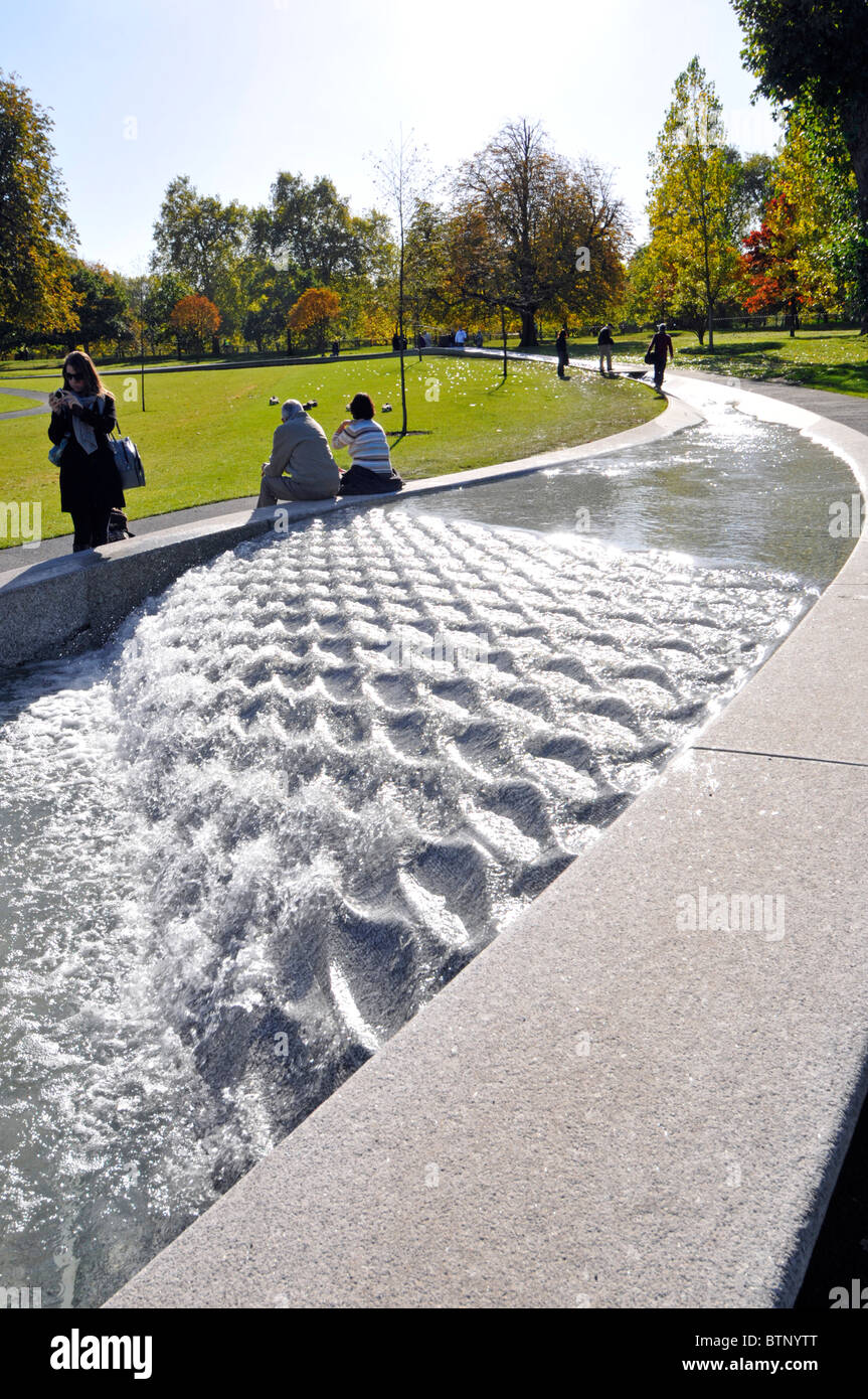 Princess Diana memorial fountain a circular artificial real life water feature with Autumn colours on trees and visitors Hyde Park London England UK Stock Photo