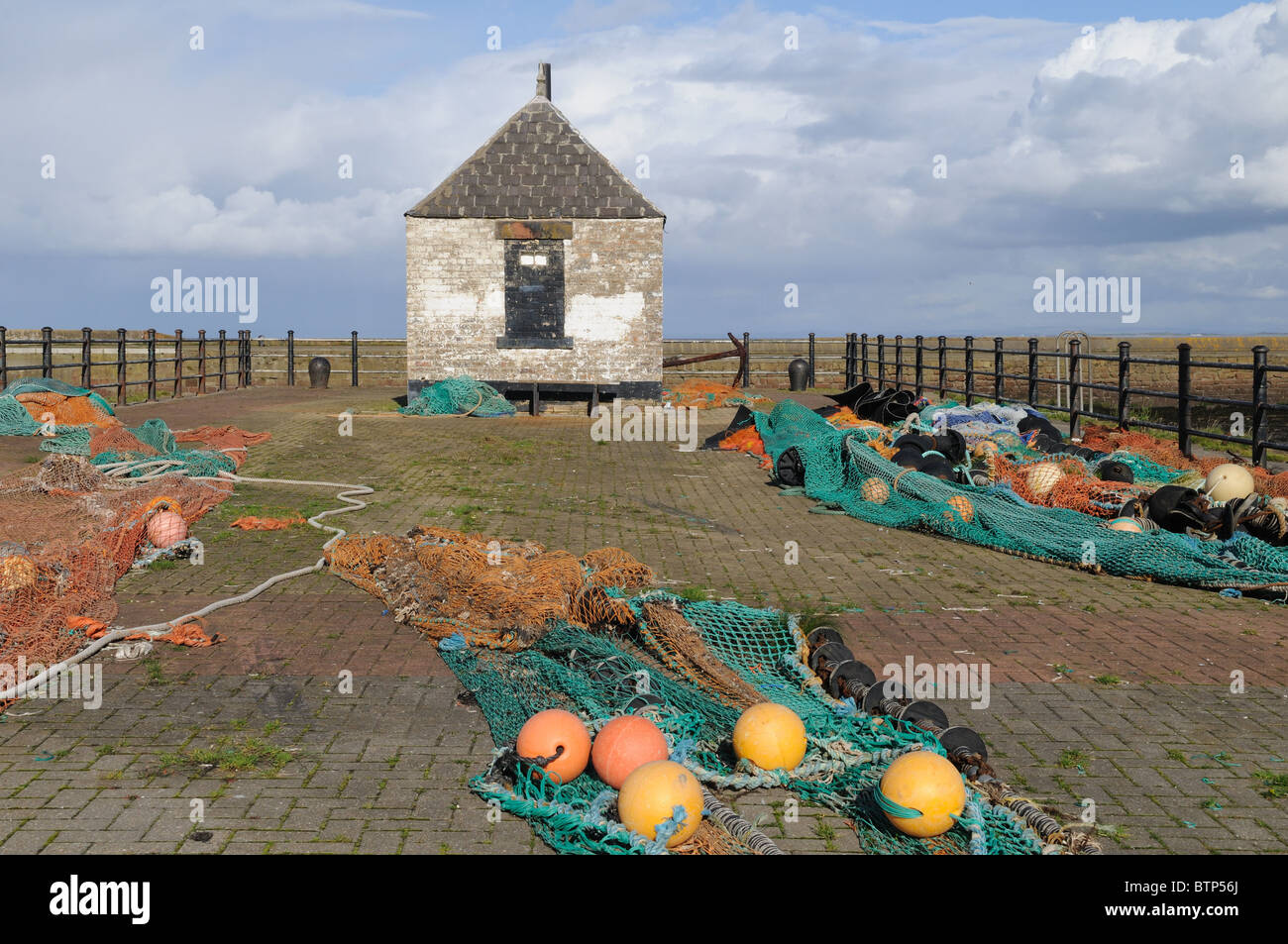 Fishing nets drying outside anold harbour light building Maryport Cumbria England UK GB Stock Photo