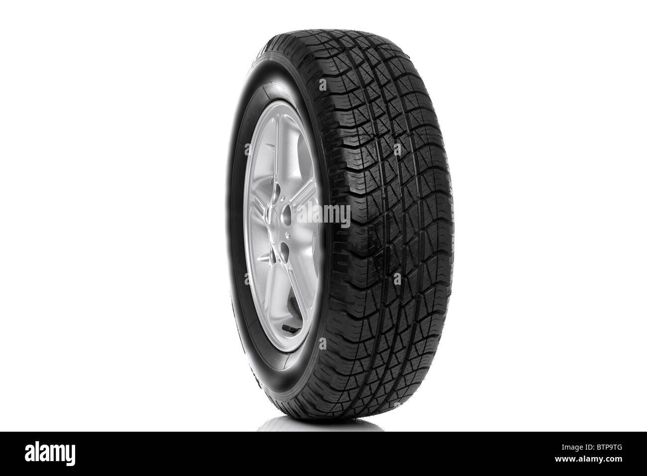 Photo of a car tyre (tire) on a five spoke alloy wheel isolated on a white background Stock Photo