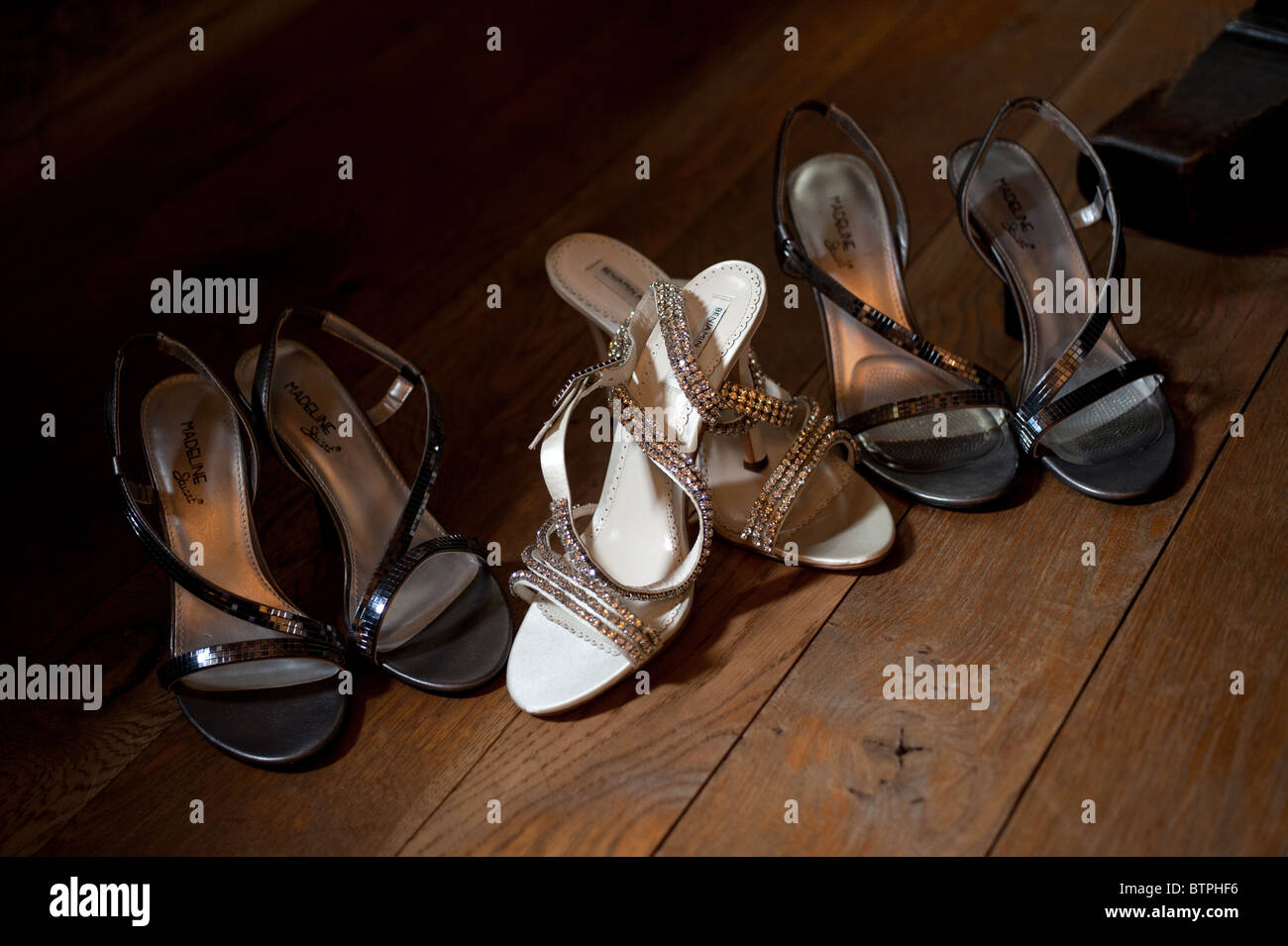Brides & bridesmaids sandals together in a pool of light on a dark wooden  floor awaiting the bridal party Stock Photo - Alamy