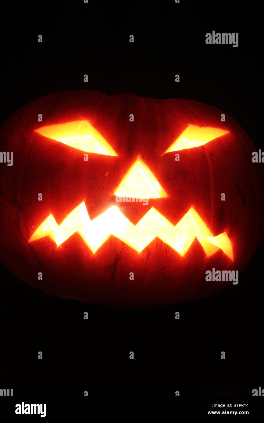 Scary Halloween pumpkin face glowing in the dark Stock Photo - Alamy