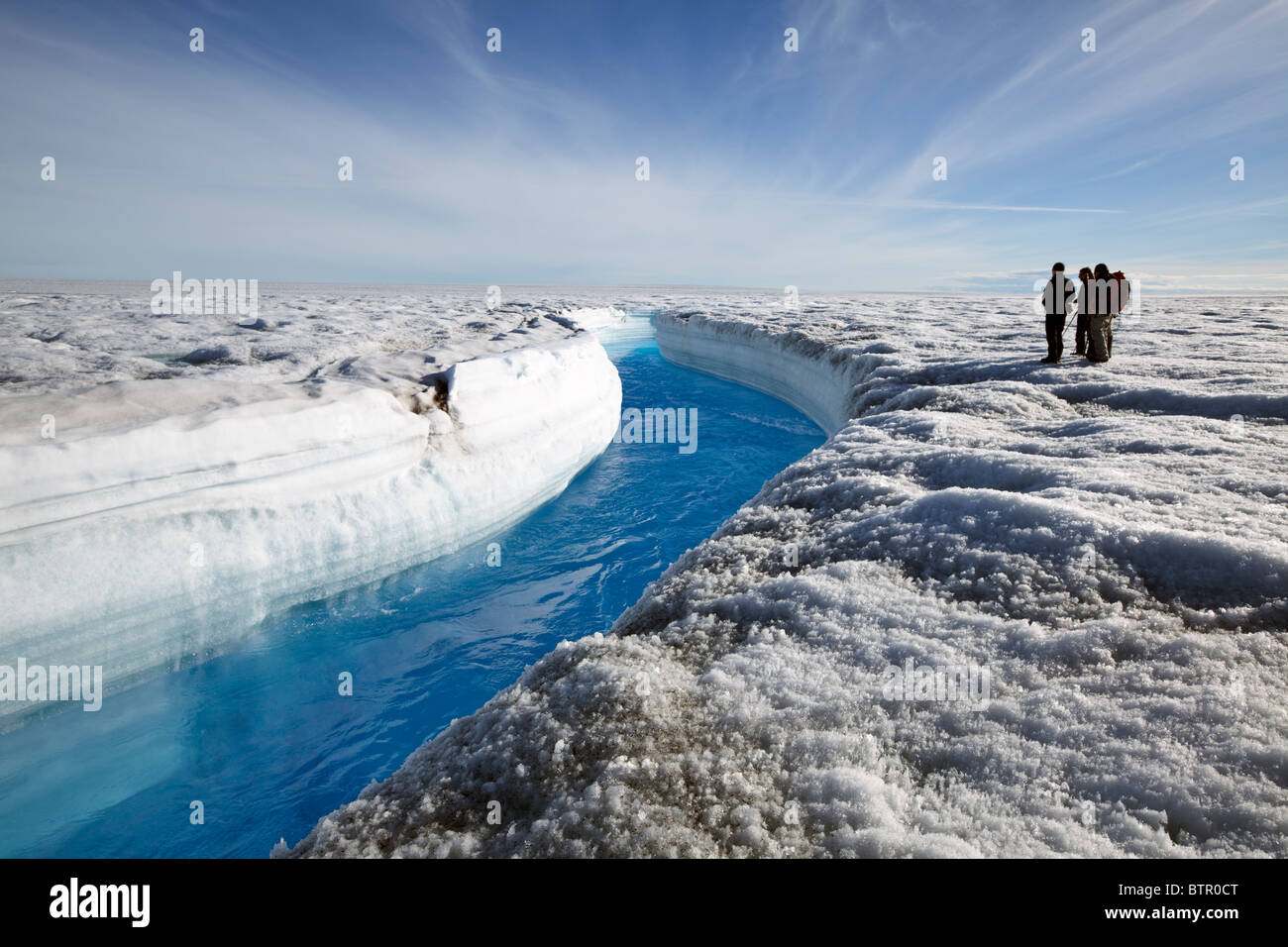 Scientists overlooking ice melt river on a glacier in Southern Greenland Stock Photo