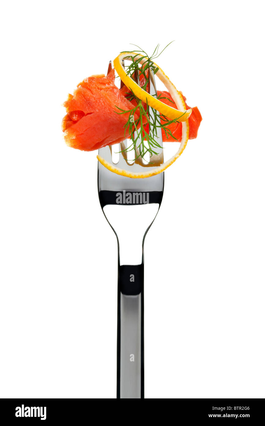 smoked salmon slice sticking on a fork, garnished with lemon peel and dill, cutout Stock Photo