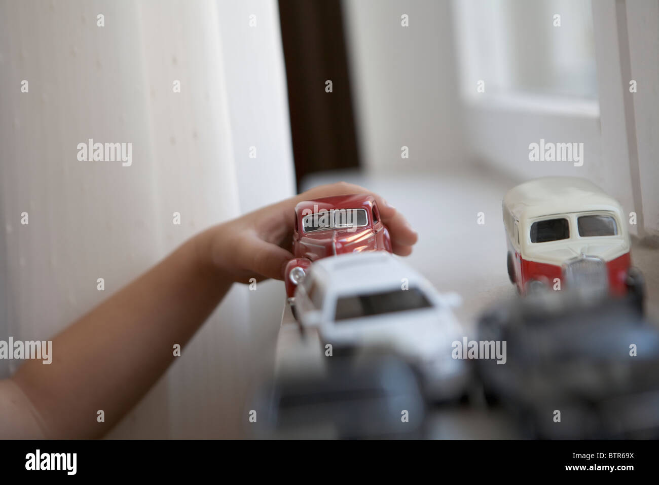 Young boy indoors playing with vintage toy cars Stock Photo