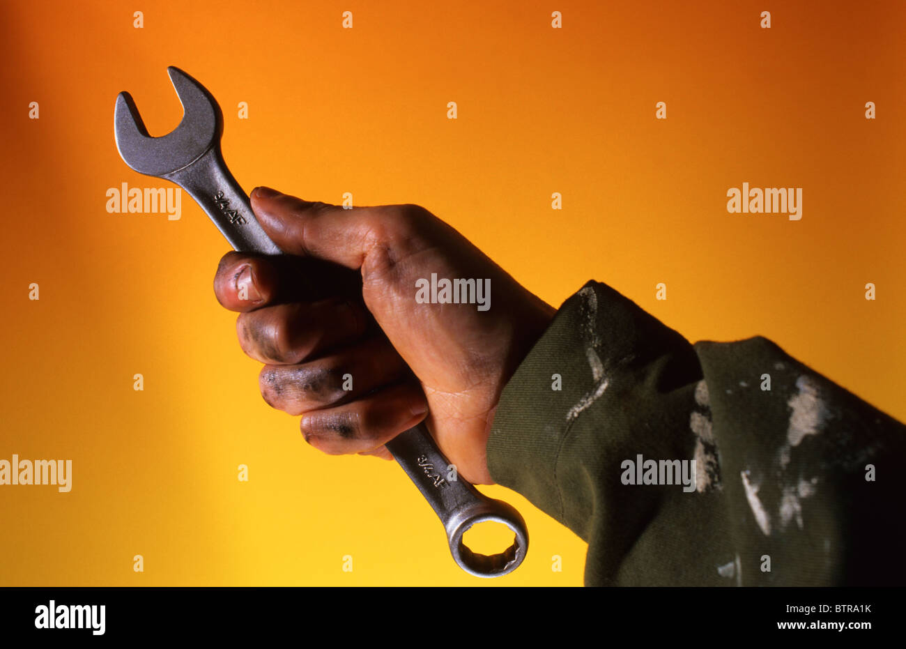 mechanic with oily hand holding spanner Stock Photo