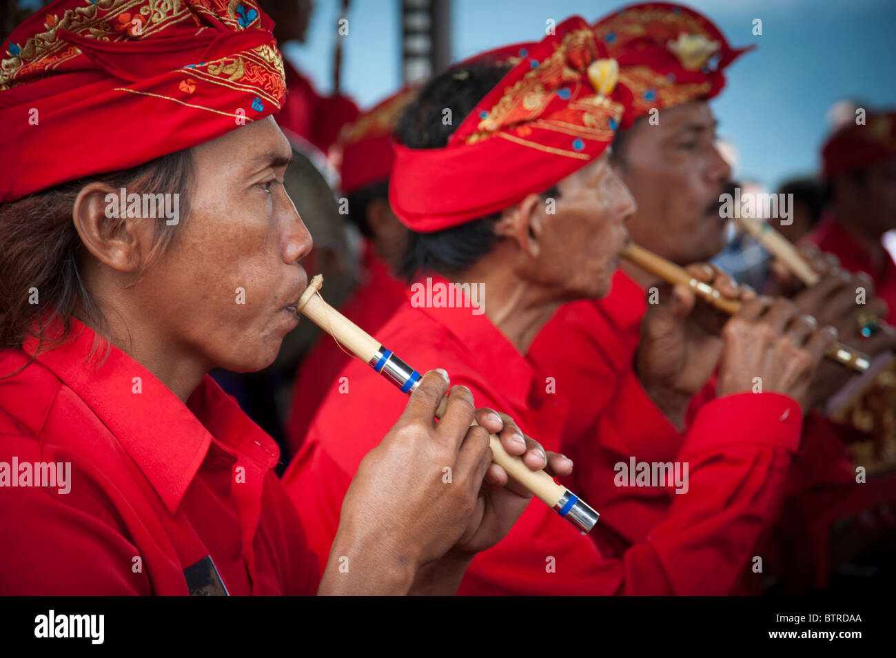 Balinese Gamelan musicians playing their instruments in Bali wearing  traditional dress with vivid red colours Stock Photo - Alamy