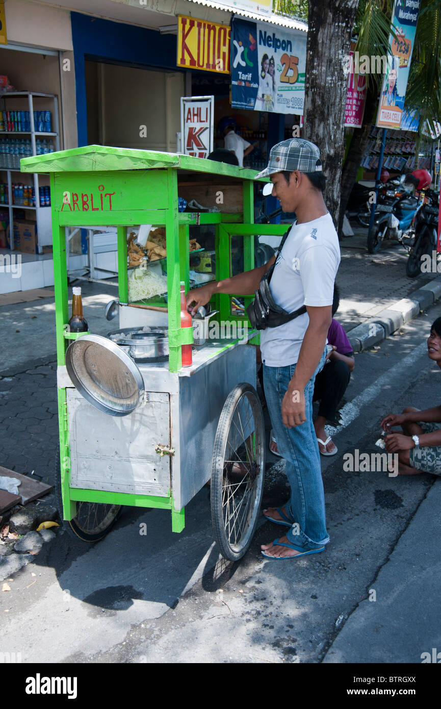 Street food vendor selling chicken dishes from a hand cart in Bali