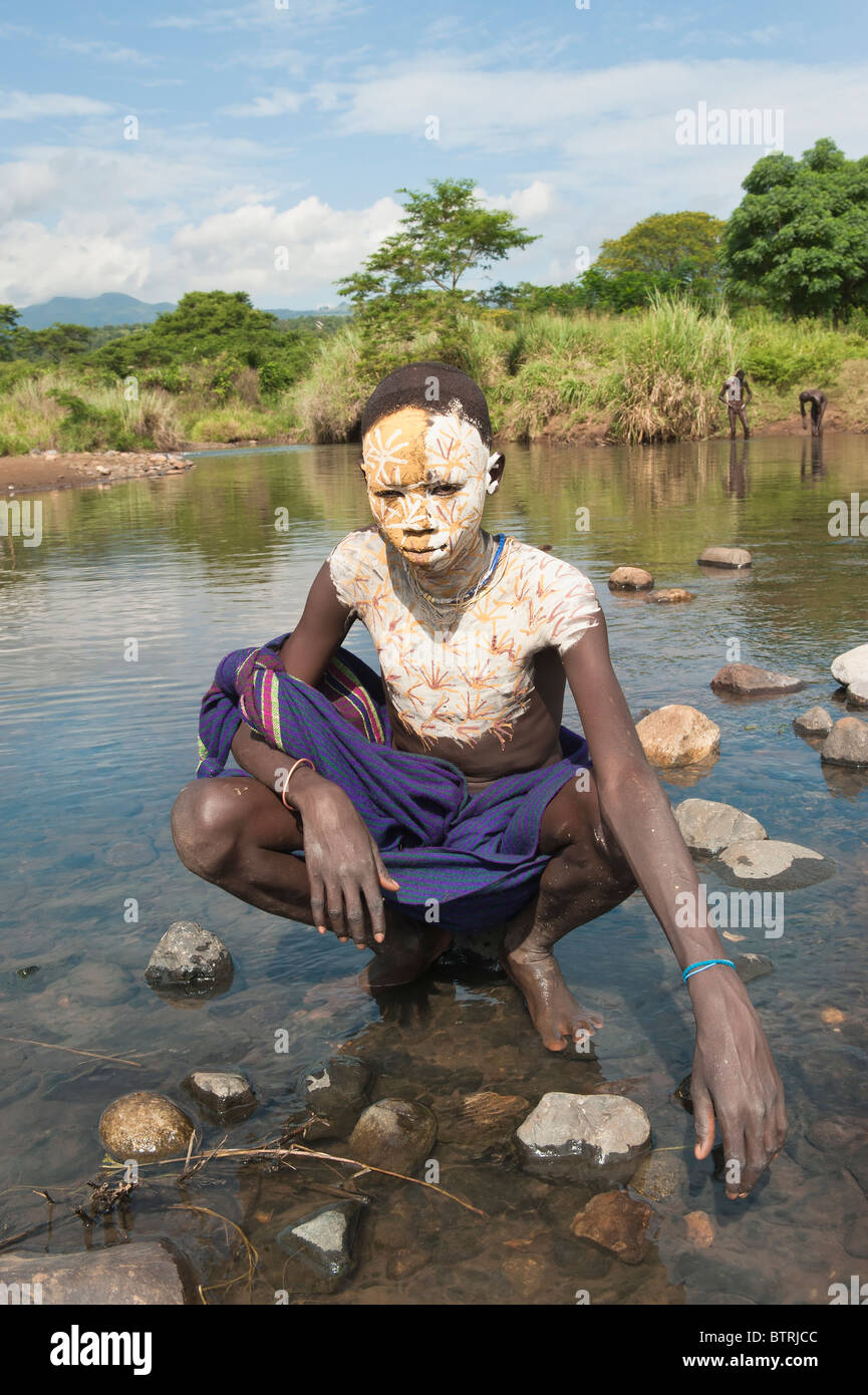 Surma boy with body paintings in the water, Kibish, Omo 