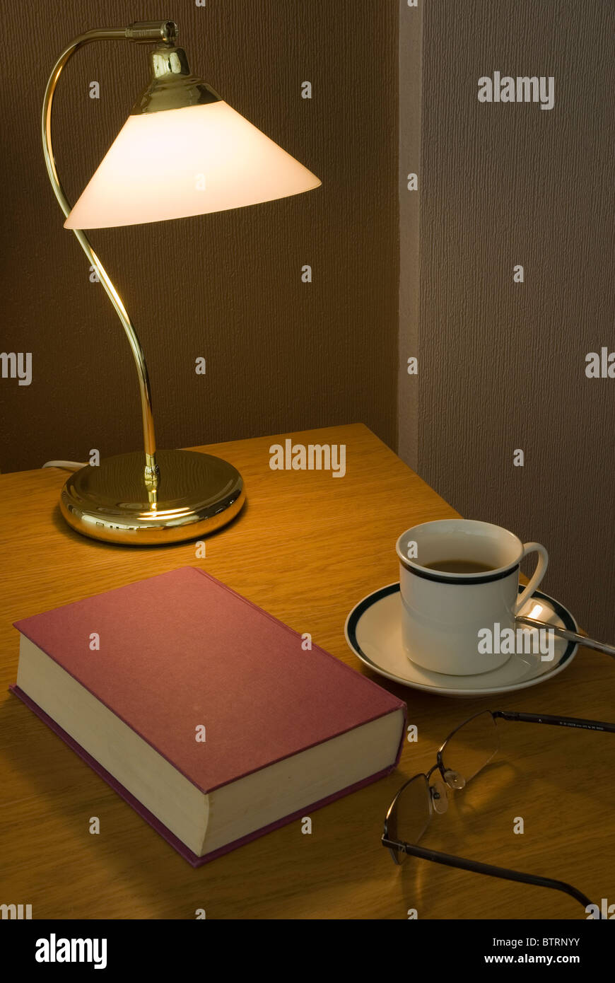 book and a cup of coffee table lamp Stock Photo