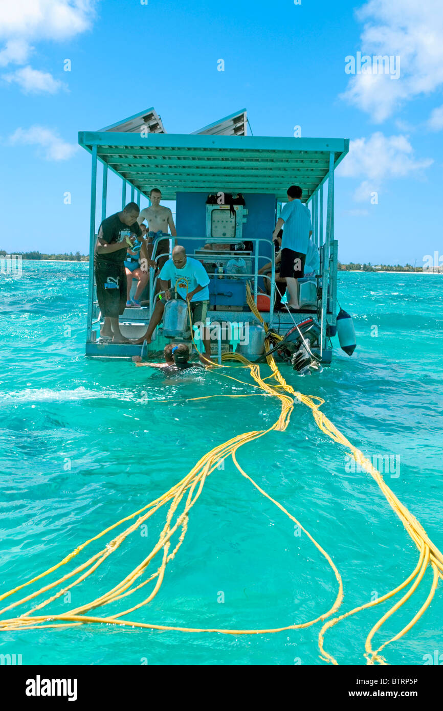 Tourists in Mauritius descending from the platform for the famous undersea walk anchored over the reef close to Grande Baie Stock Photo
