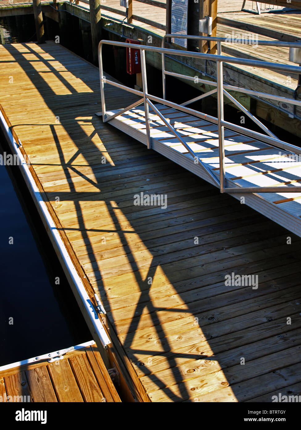 boat ship fishing vessel dock metal ramp shadows wooden ocean Stock Photo