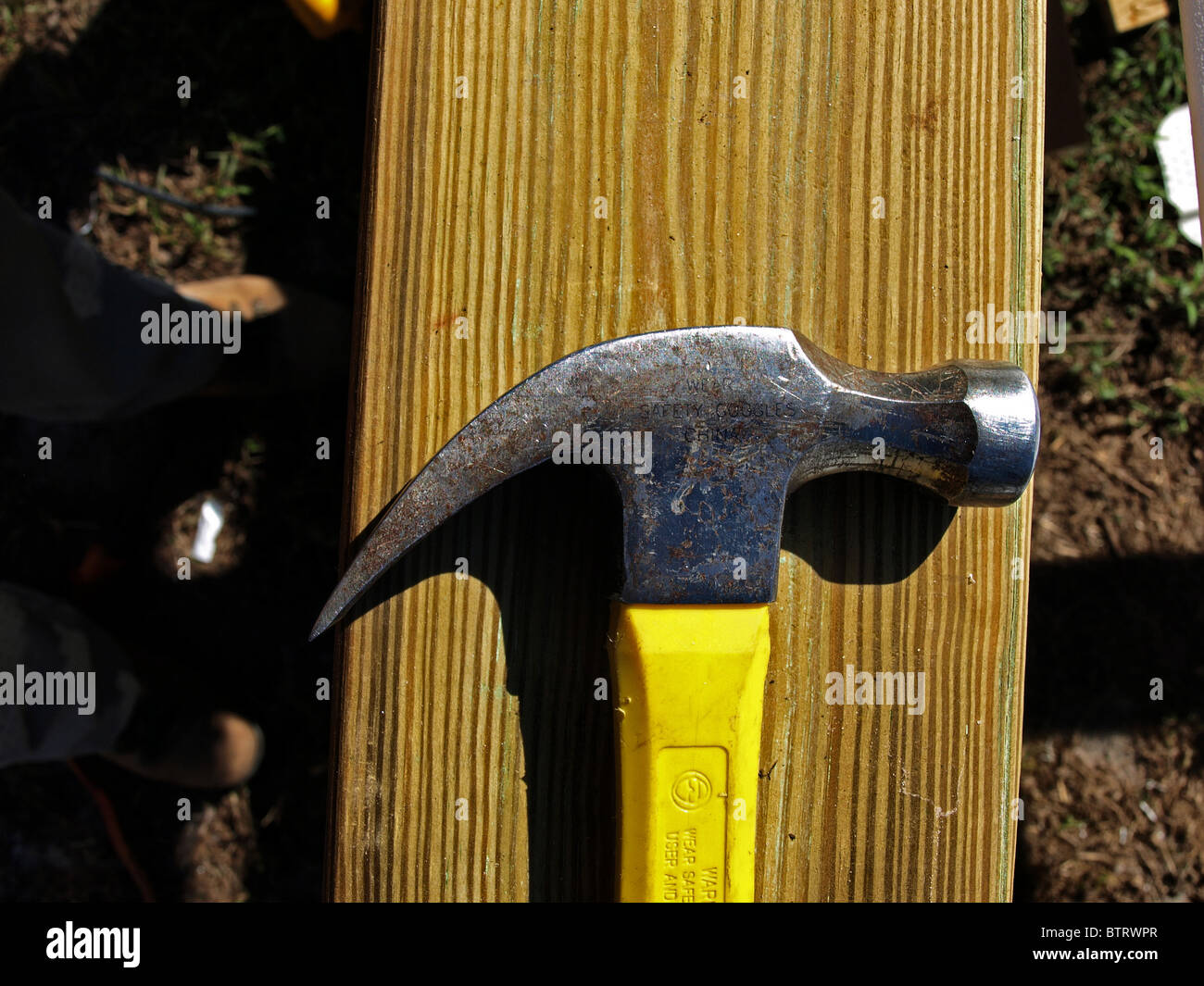 claw hammer construction building yellow head metal handle on wood