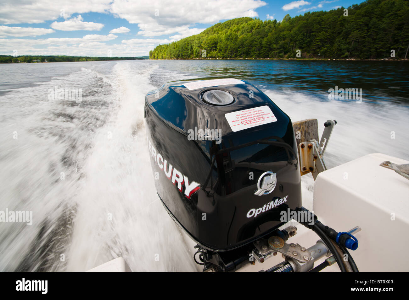 A Mercury Optimax outboard motor powers a speedboat through the water