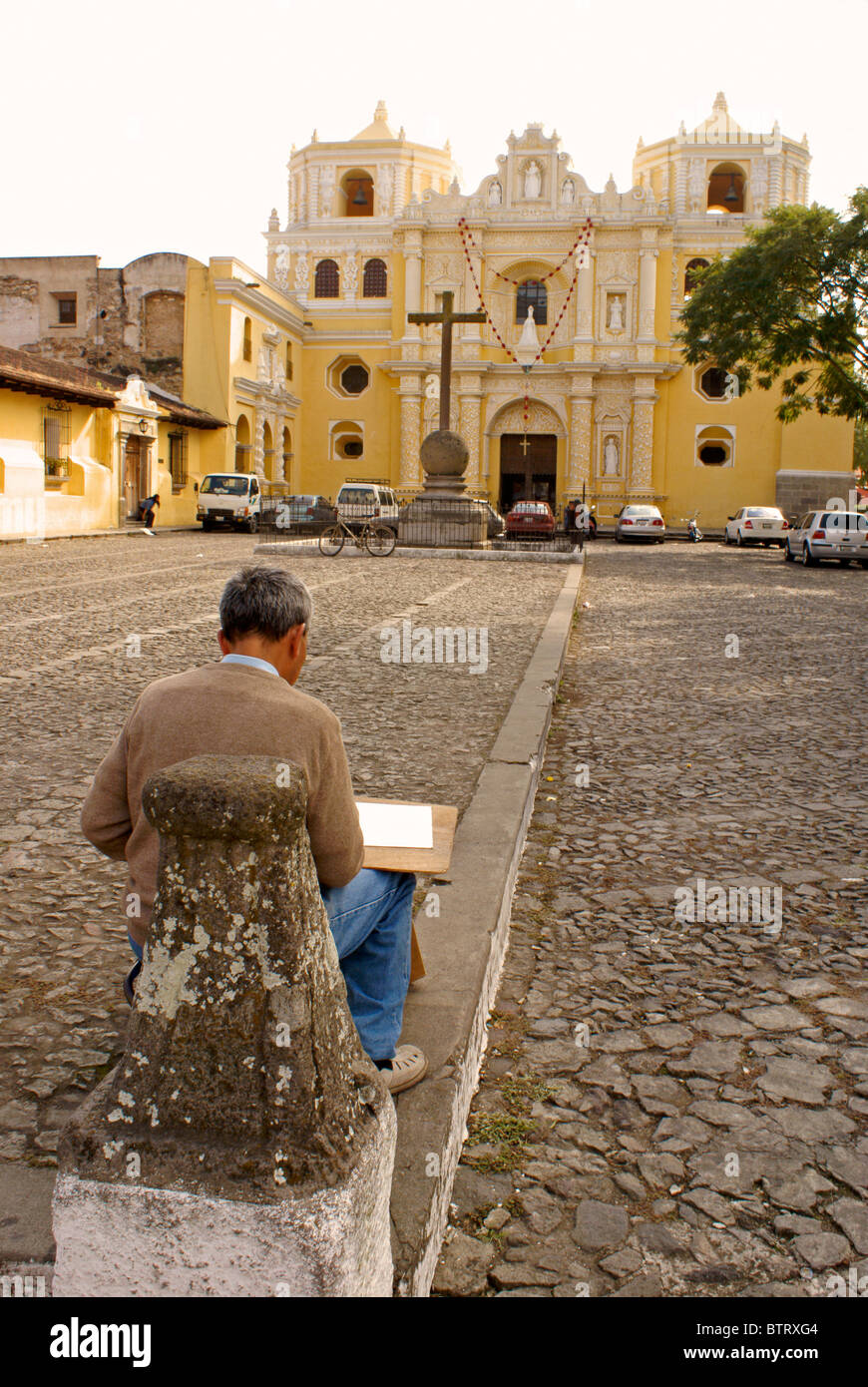 Artist sketching La Merced Church in Antigua, Guatemala. Antigua is a UNESCO World heritage site. Stock Photo
