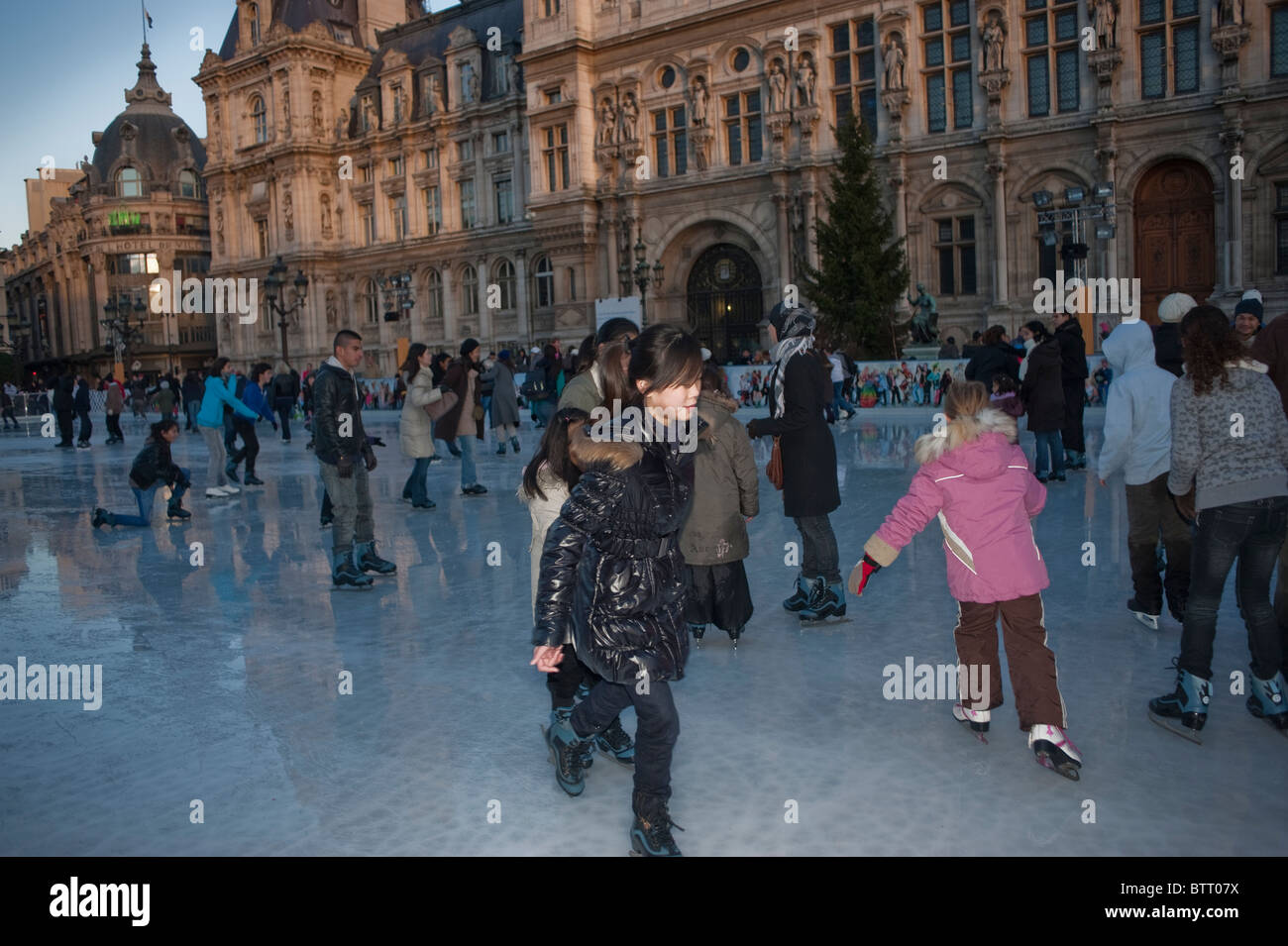 Teenagers Ice Skaters on Ice Skating Rink at Paris City Hall Building