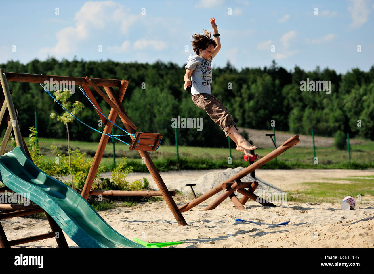 Young teen jumping from a swing, high jump Stock Photo