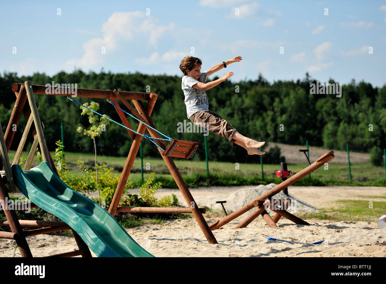 Young teen jumping from a swing, high jump Stock Photo