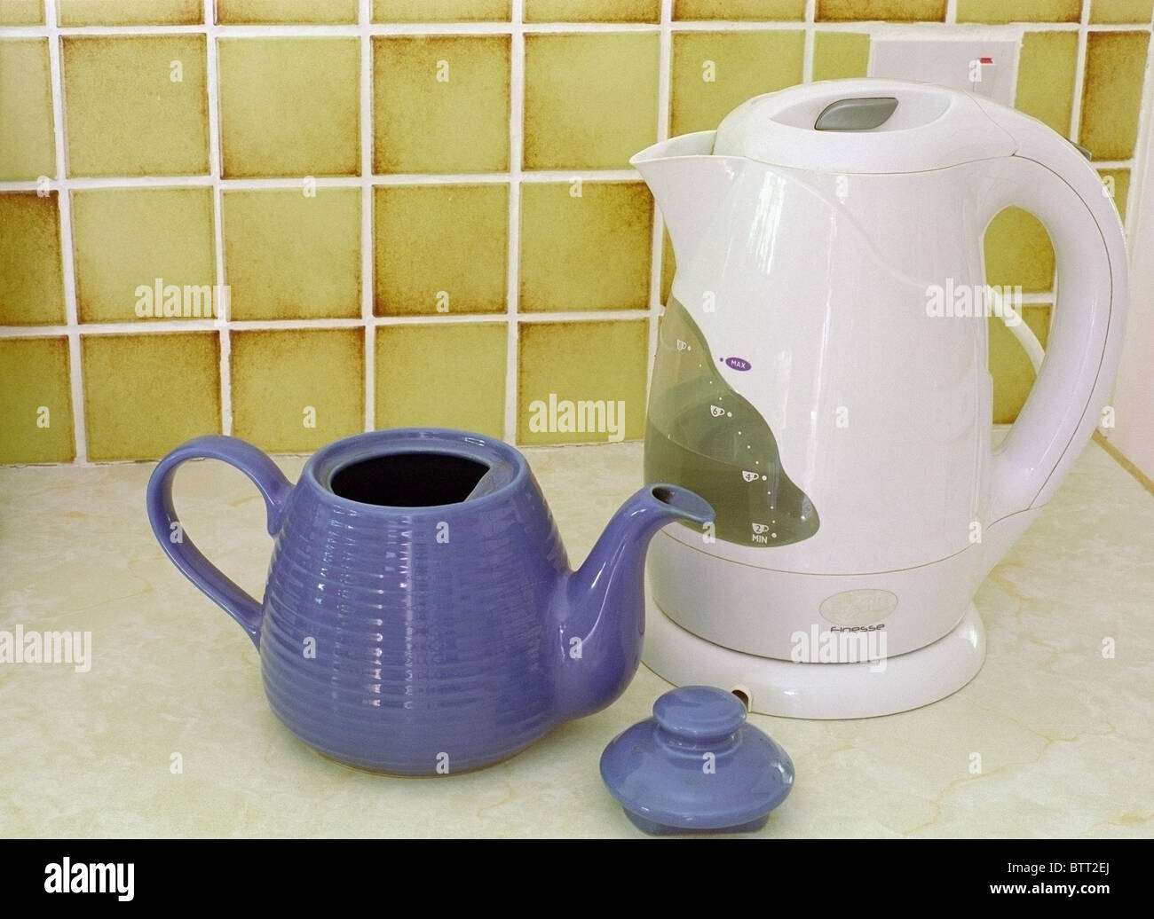 Electric Cordless White Plastic Kettle and Blue Ceramic Teapot on a