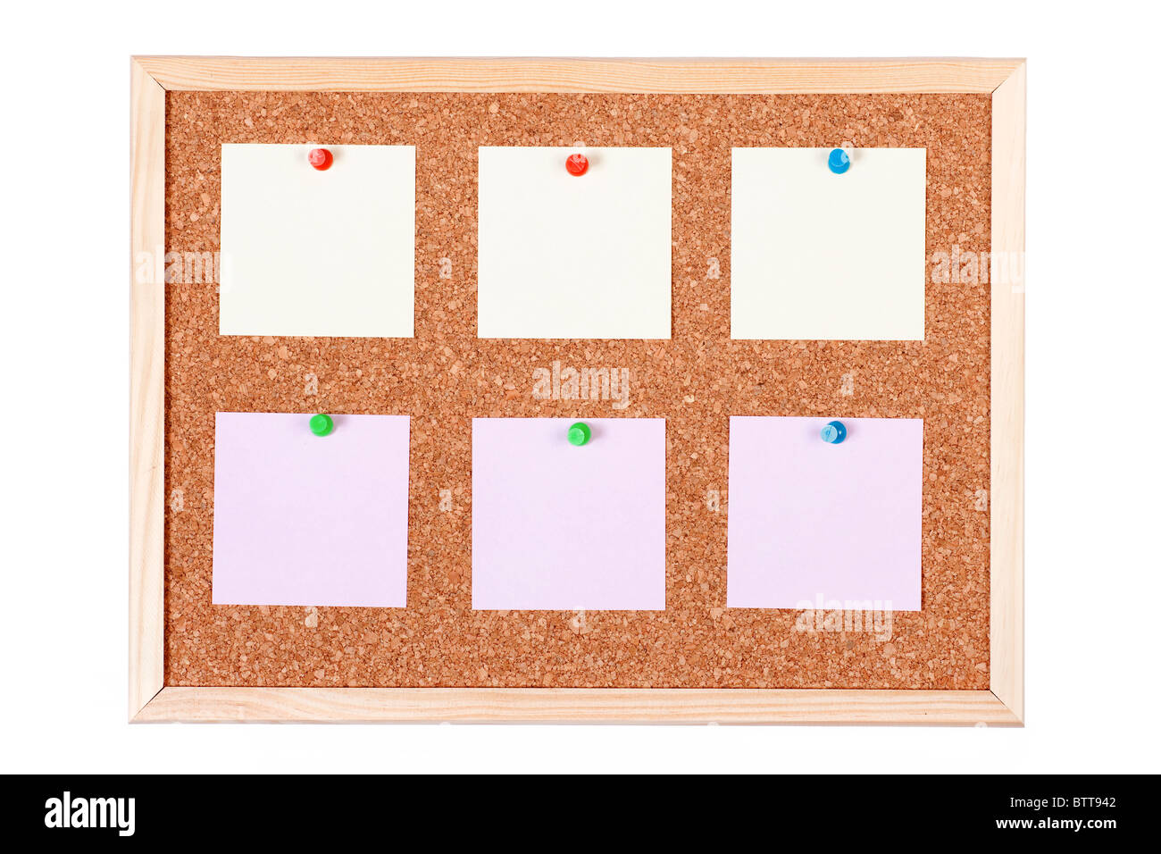 Pieces of note paper on a cork bulletin board, isolated on white background. Stock Photo