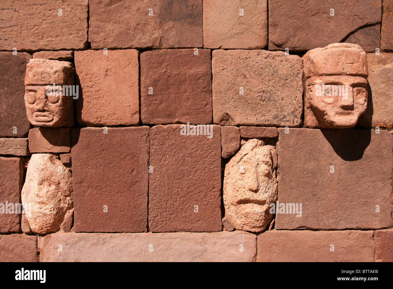 Multiple Stone faces built into a wall in Tiahuanaco or Tiwanaku, the capital of the Pre-Inca Civilization in Bolivia Stock Photo