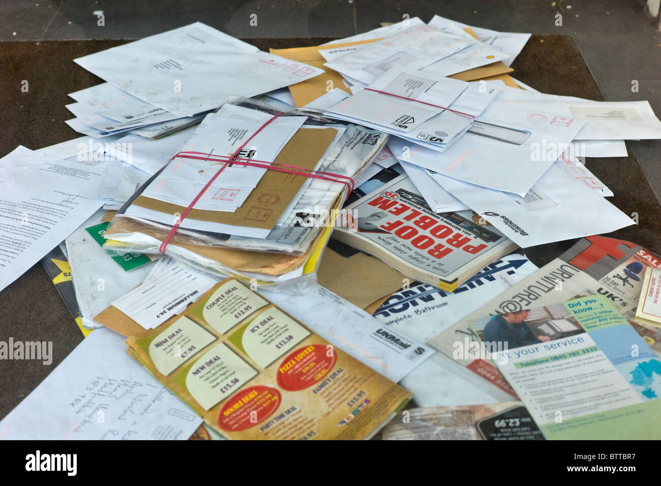 a pile of unopened mail on the doormat of a closed down business Stock Photo