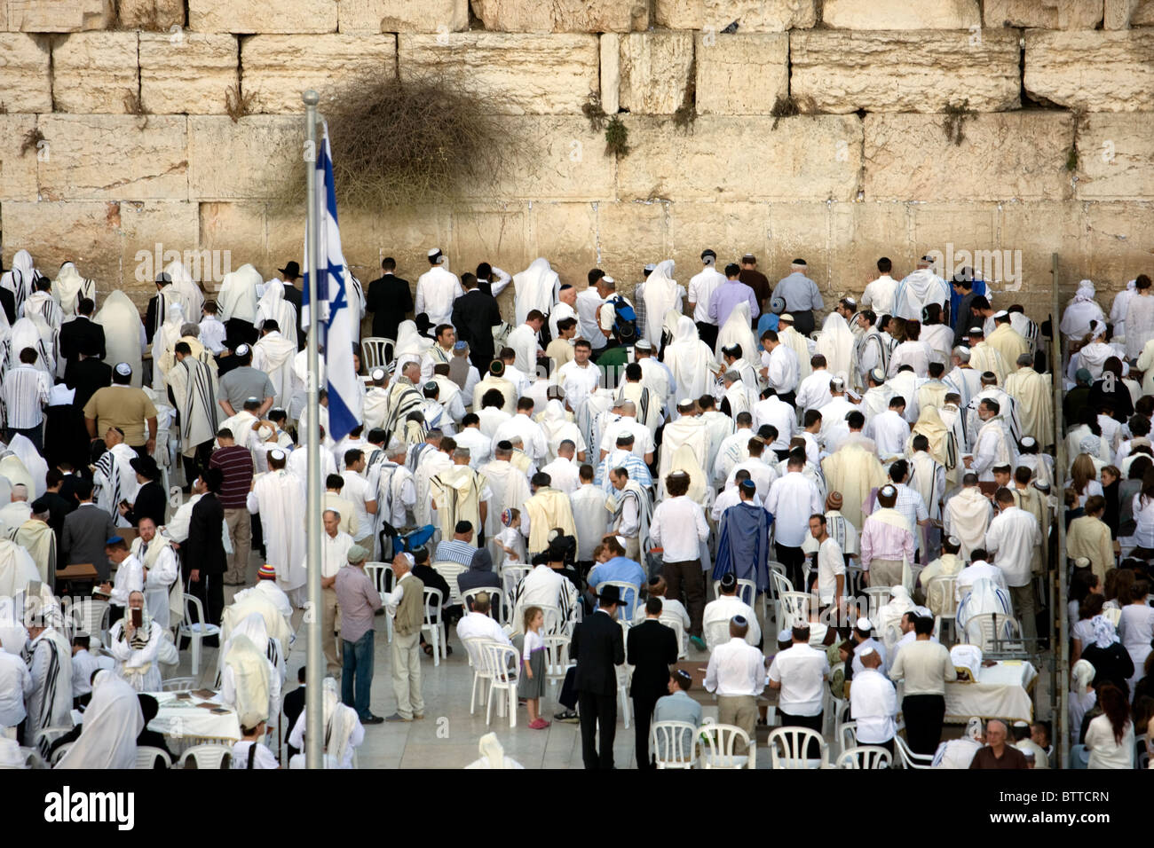 Jewish religious man with traditional clothes pray at the Wailing Wall