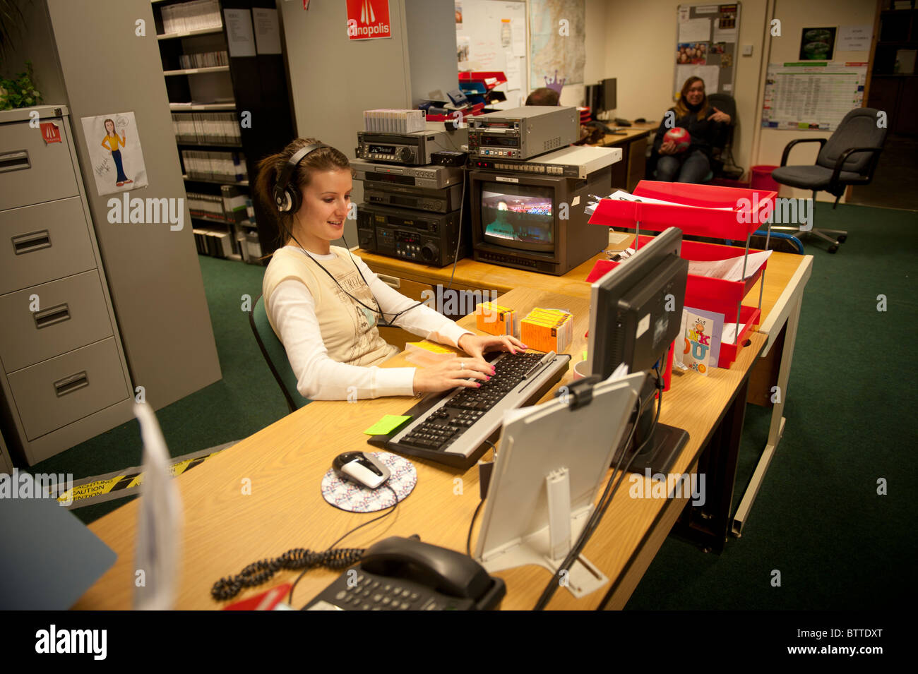 A woman worker logging video content at Tinopolis television and media company, Llanelli Wales UK Stock Photo