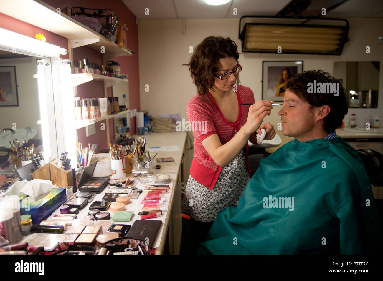Makeup artist preparing presenters at Tinopolis television and media company, Llanelli Wales UK Stock Photo