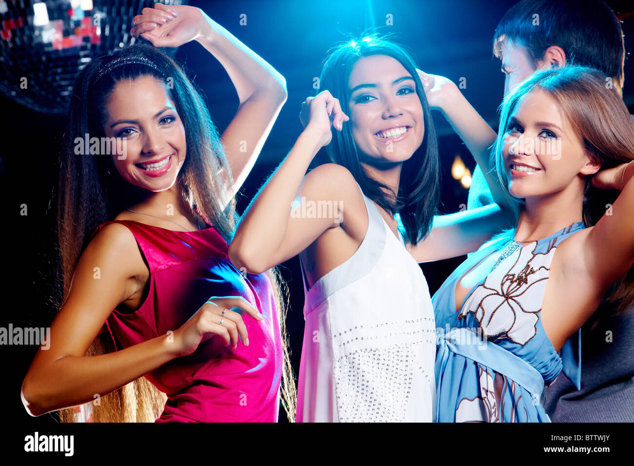 Three glamorous girls enjoying themselves while dancing in night club ...
