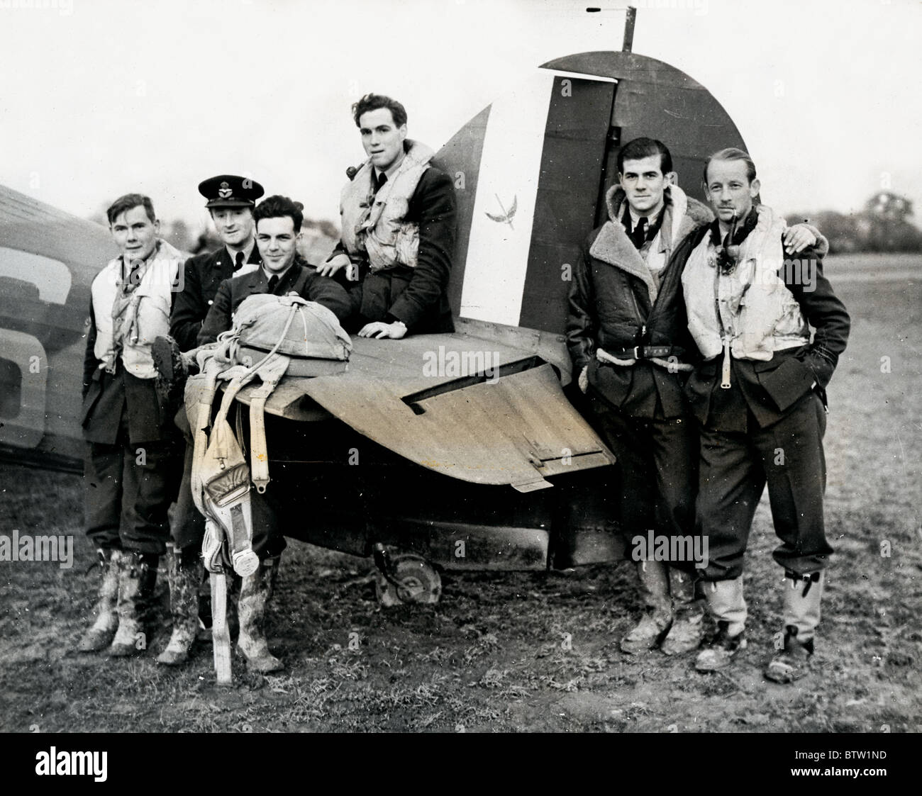 Group of pilots from City of London 601 Squadron of the Auxiliary Air Force showing squadron badge on tail of a Hurricane Stock Photo