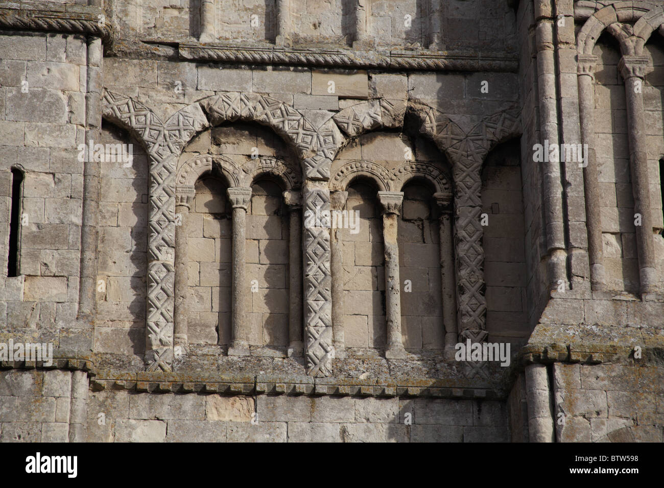 12th century Norman blind arches with diaper carving details on the tower Malmesbury Abbey, Wiltshire Stock Photo
