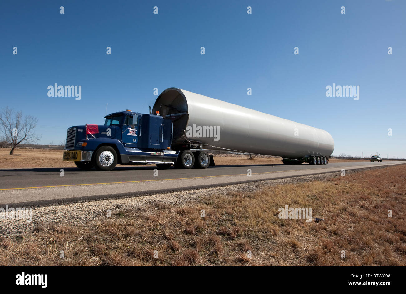 Tractor-trailer truck in a rural area near San Angelo TX hauls component of a high-tech windmill to a wind farm in West Texas. Stock Photo