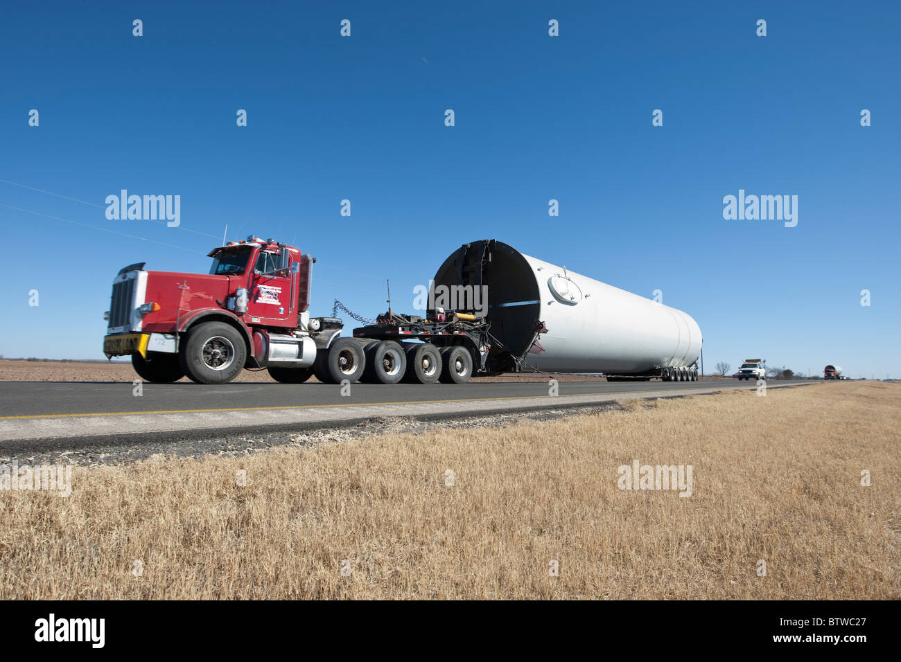 Tractor-trailer truck in a rural area near San Angelo TX hauls component of a high-tech windmill to a wind farm in West Texas. Stock Photo