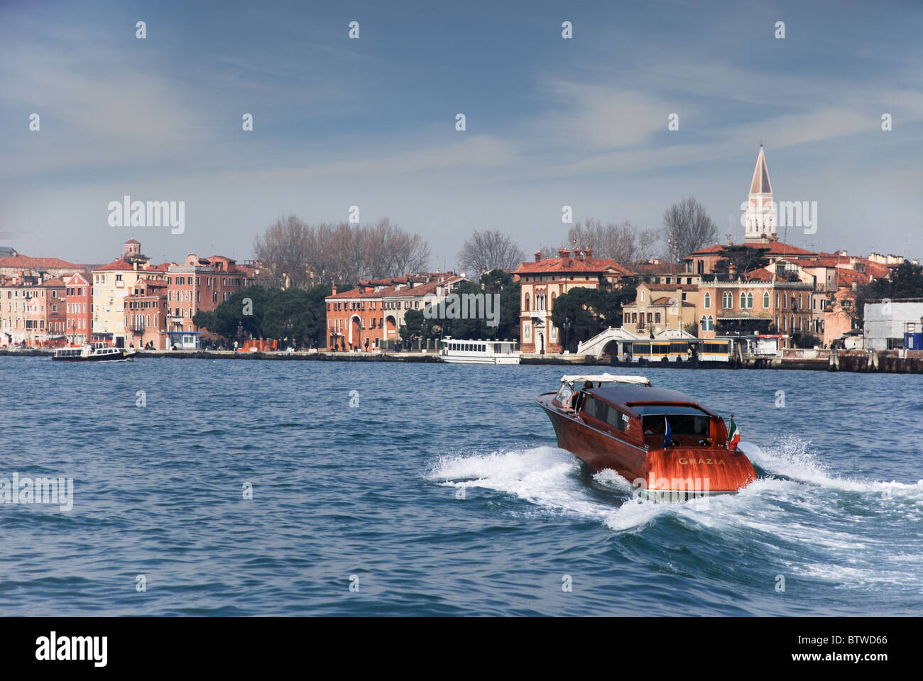 A 'Grazia' boat speeds across the bay towards St Mark's / San Marco Square Venice Italy Stock Photo