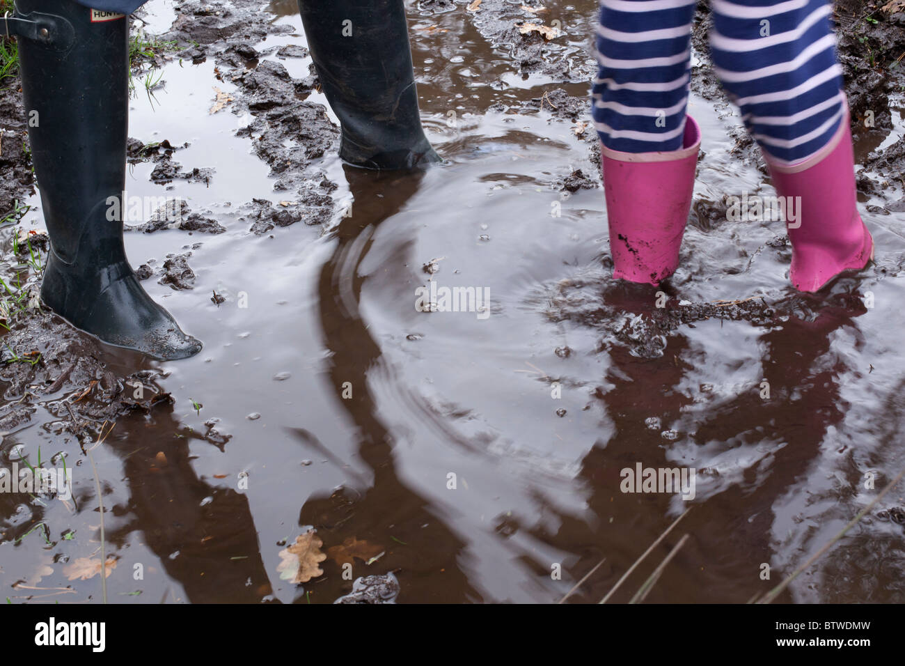 Kids playing in puddle Stock Photo