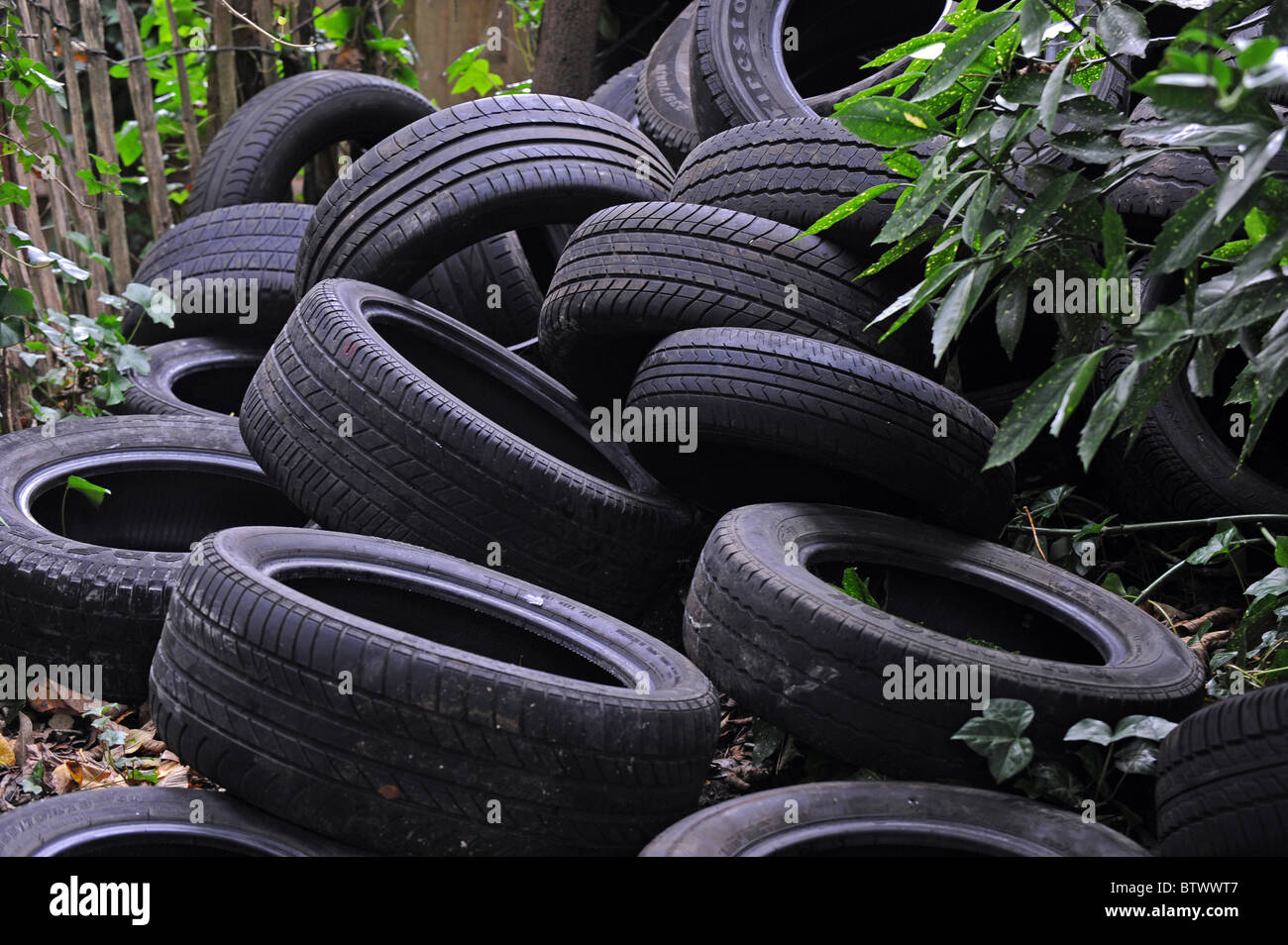 A large pile of fly tipped tyres dumped on waste ground in Brighton Stock Photo
