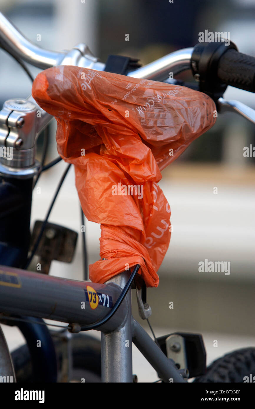 A plastic bag pictured covering a bike seat to keep it dry in Brighton, East Sussex, UK. Stock Photo