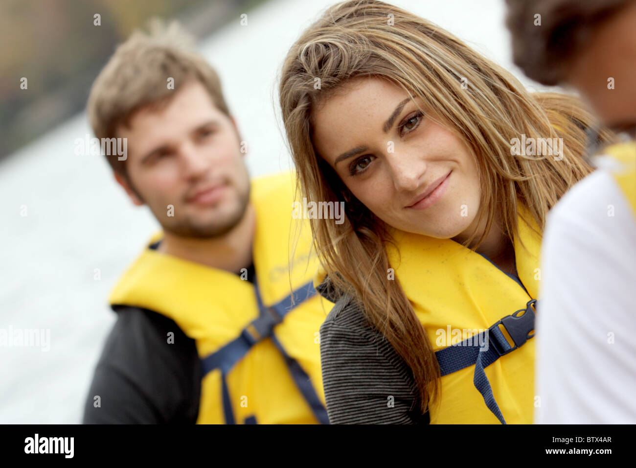 Young couple rowing in a Canoe in life jackets Stock Photo