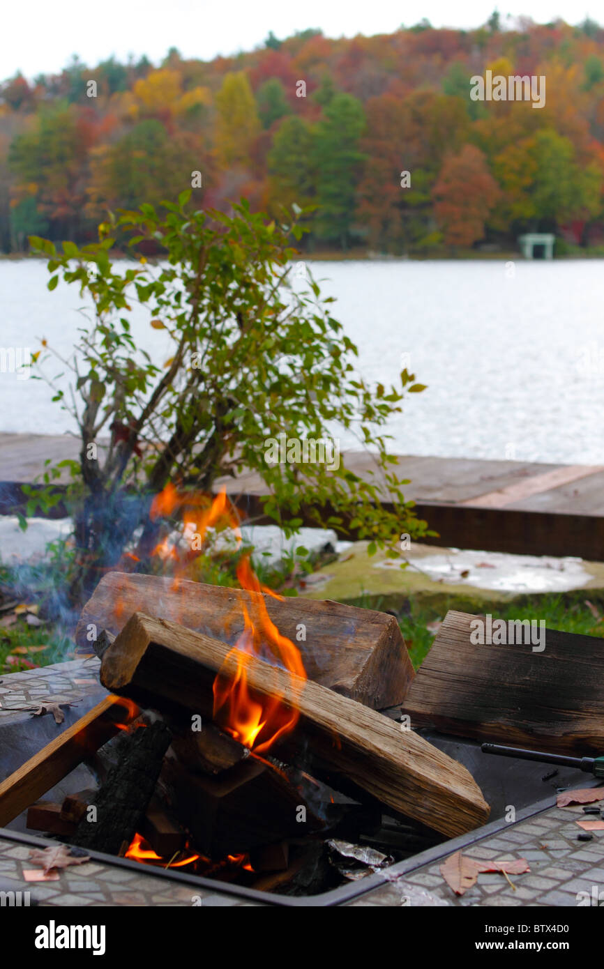 Campfire on lake in fall Stock Photo