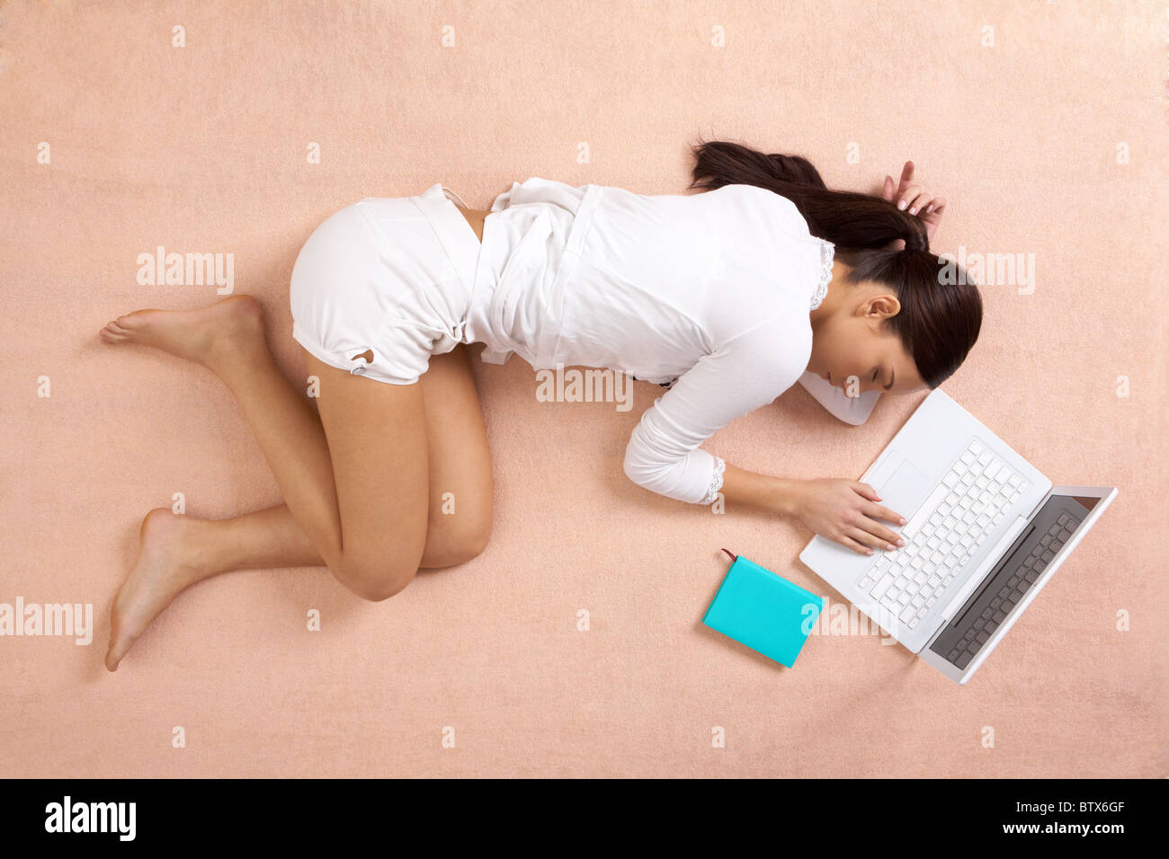View from above of peaceful girl having a nap with laptop near by Stock Photo