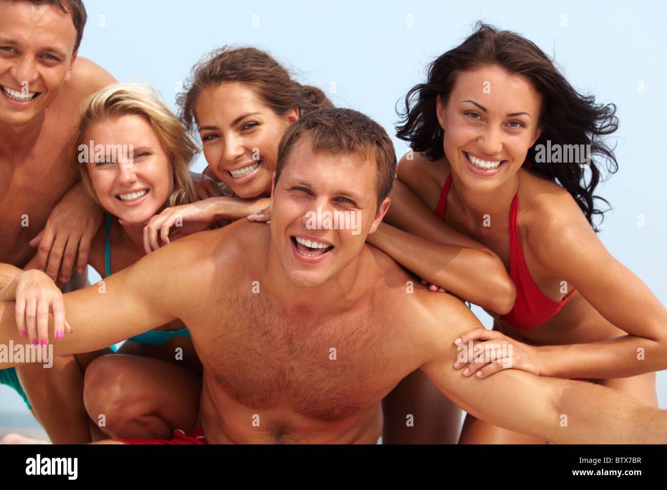 Portrait of joyful guy and happy girls in bikini on background looking at  camera on summer vacation Stock Photo - Alamy