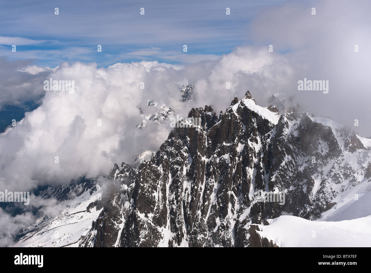 Cloudy mountain peaks in snow. French Alps over Chamonix. Popular skiing area. Stock Photo